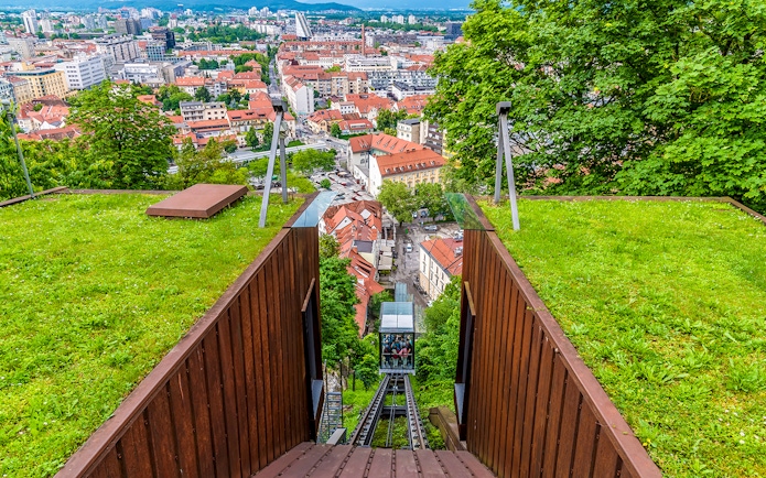 Funicular railway leading to Ljubljana Castle with city view below.