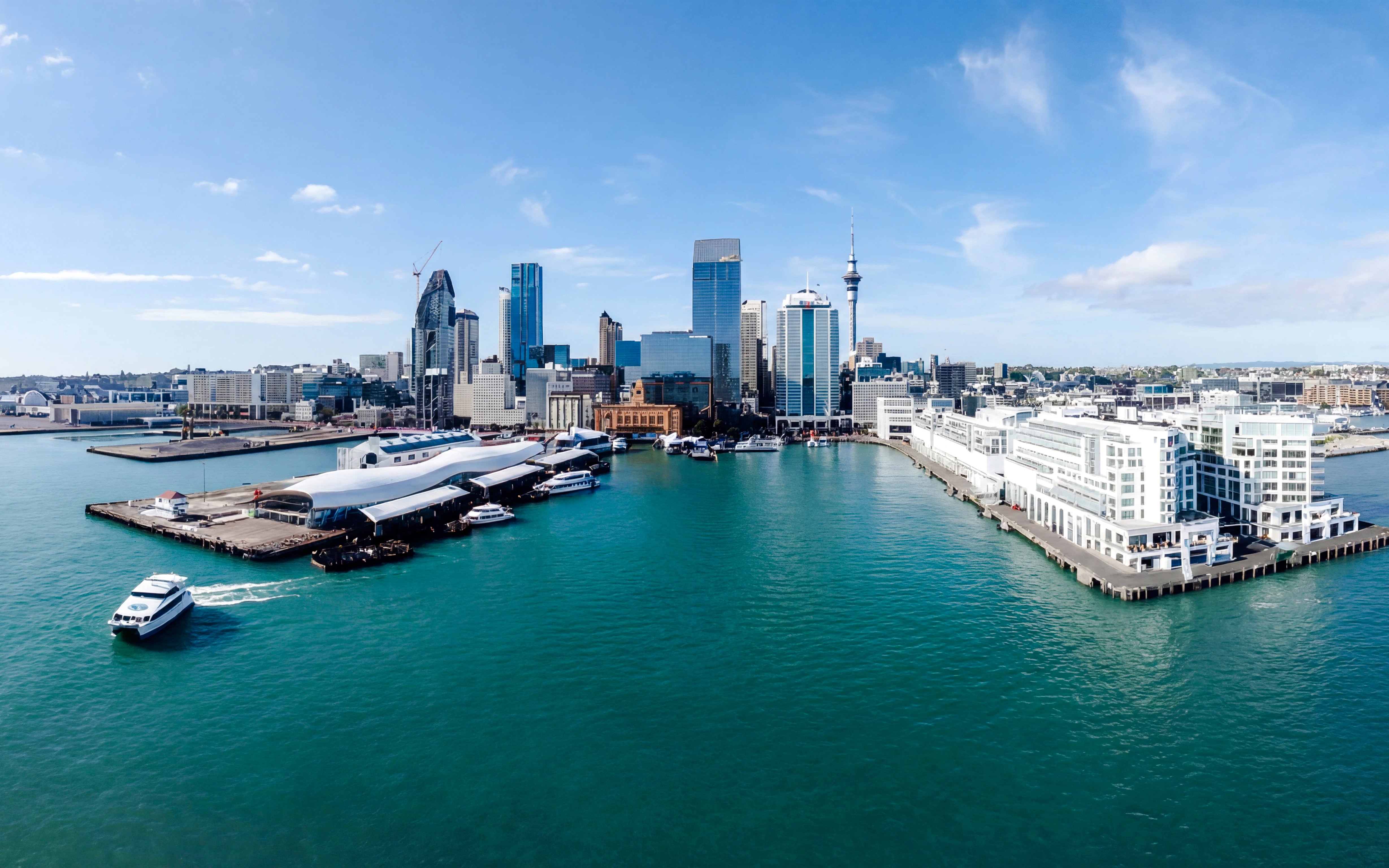 Auckland Harbour with skyline and cruise boat on scenic sightseeing tour.