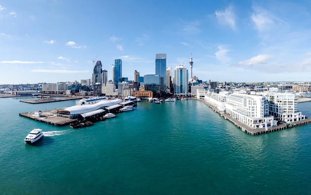 Auckland Harbour with skyline and cruise boat on scenic sightseeing tour.