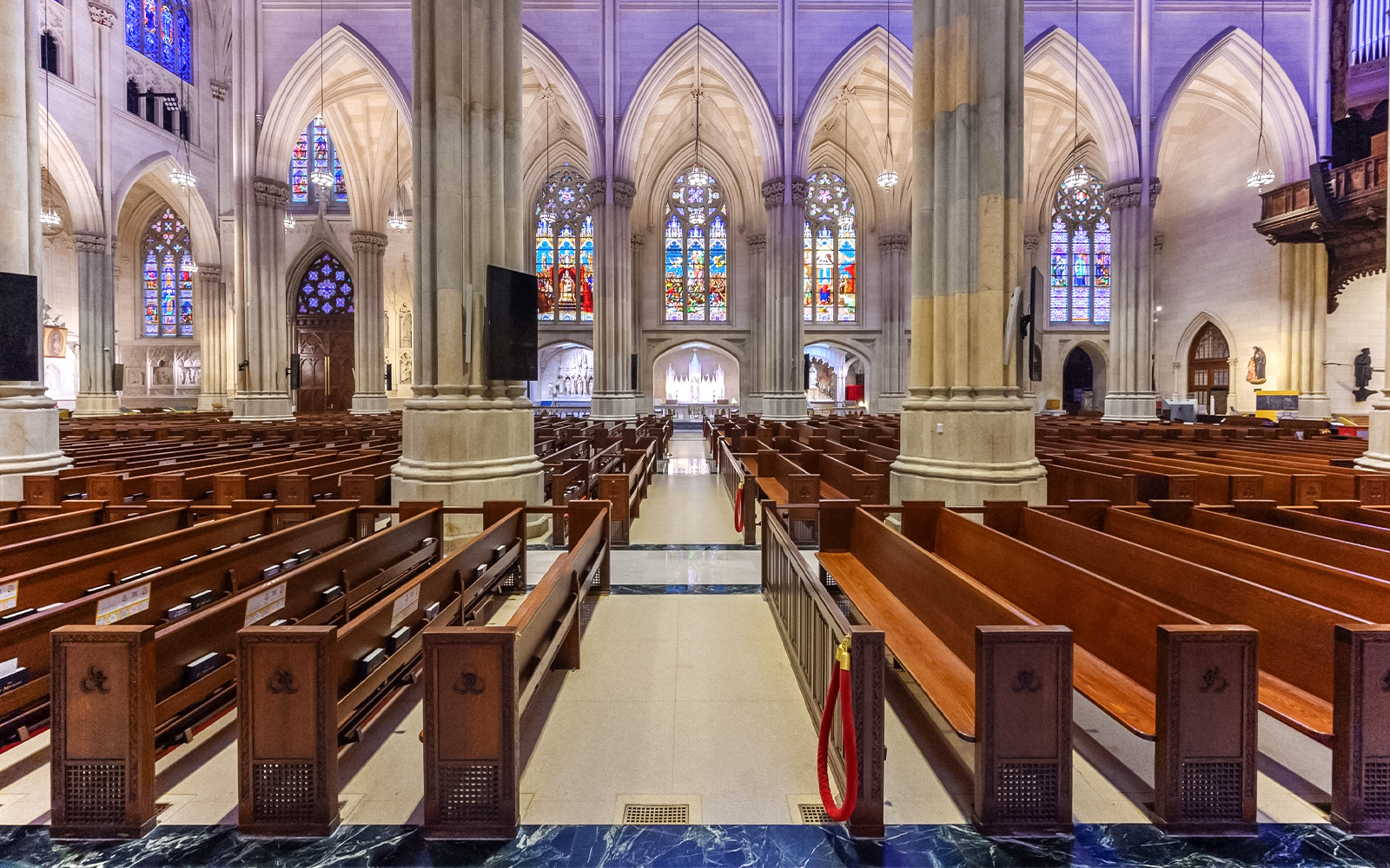 St. Patrick's Cathedral interior with stained glass windows and wooden pews, New York City.