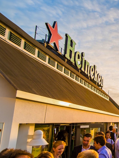 Crowd enjoying sunset at Heineken Experience rooftop in Amsterdam.