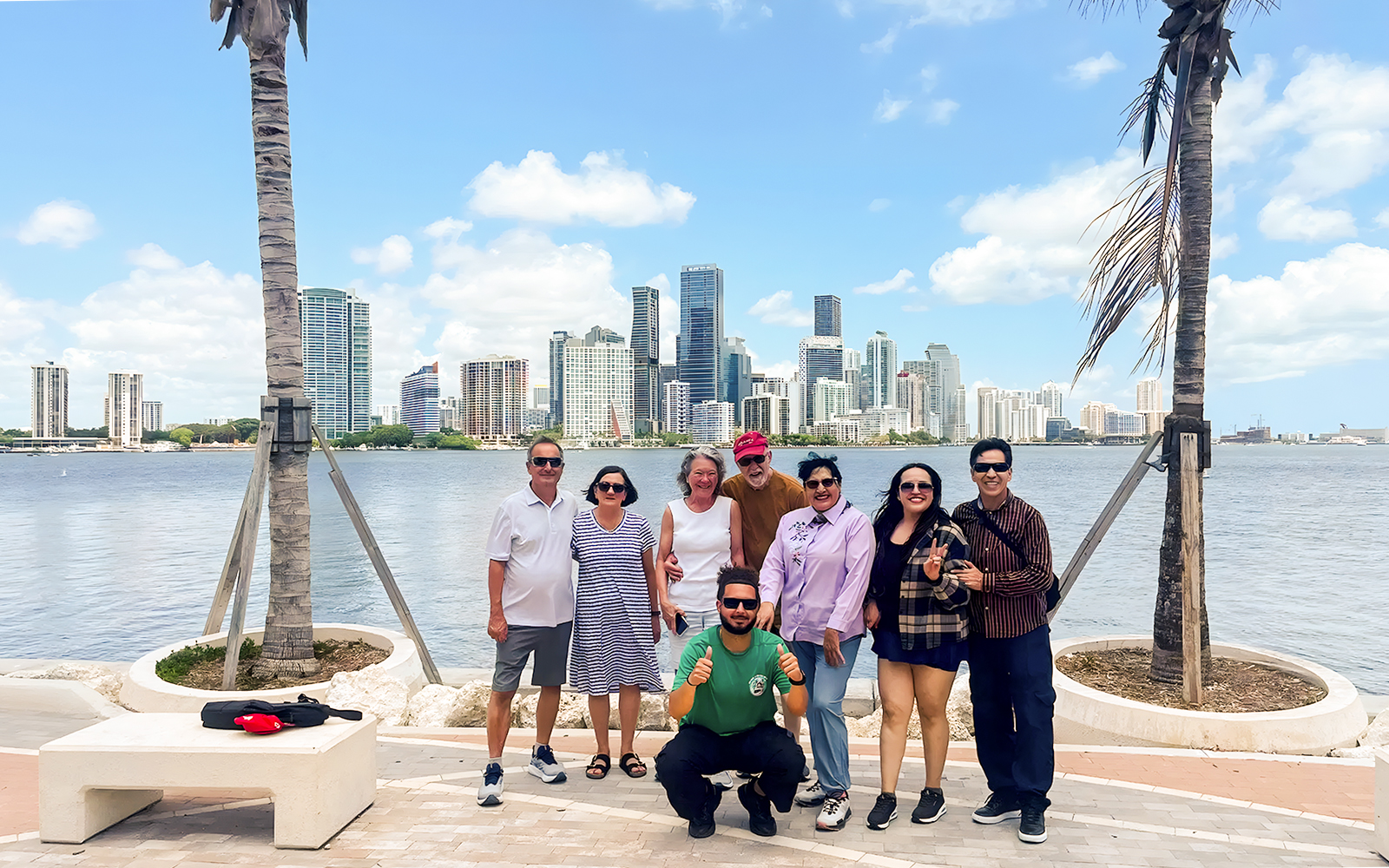 Group posing at Bayside Marketplace with Miami skyline in the background.