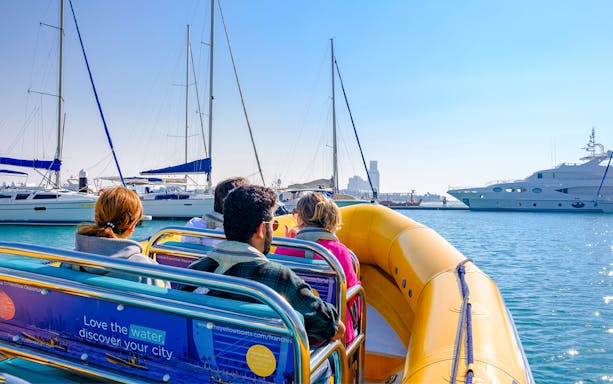 Speed boat with tourists cruising near yachts at Al Marjan Island.