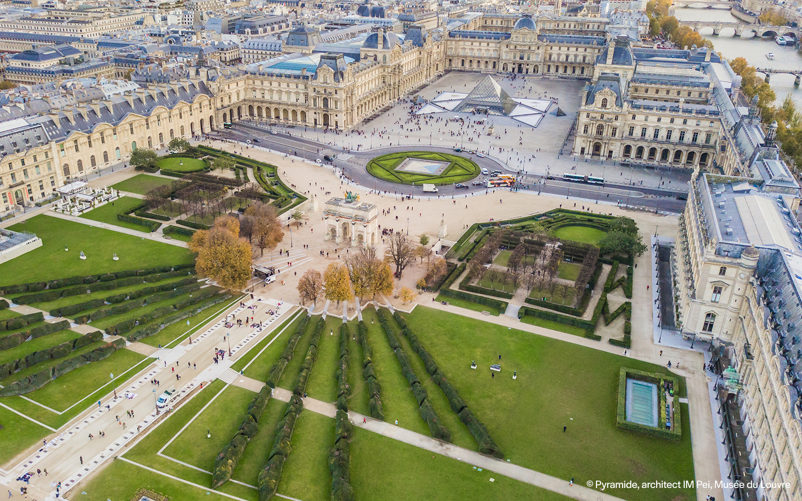 Aerial view of the Louvre Museum in Paris with the Seine River in the background.