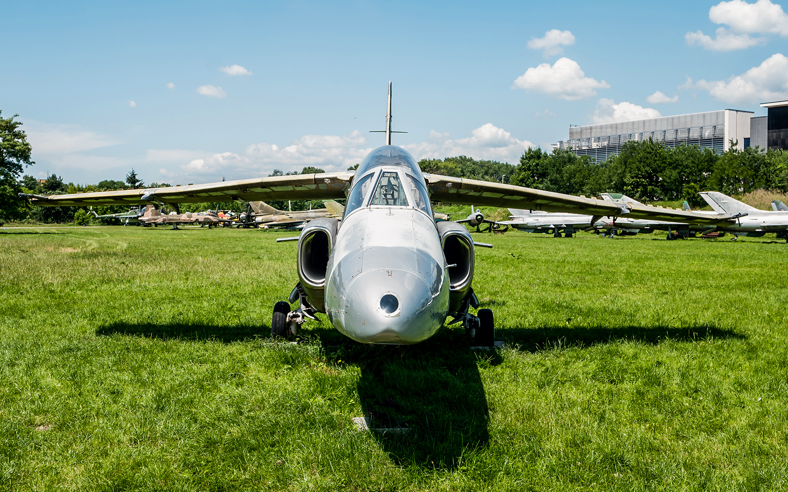 Jet aircraft displayed on grass at Polish Museum of Aviation.
