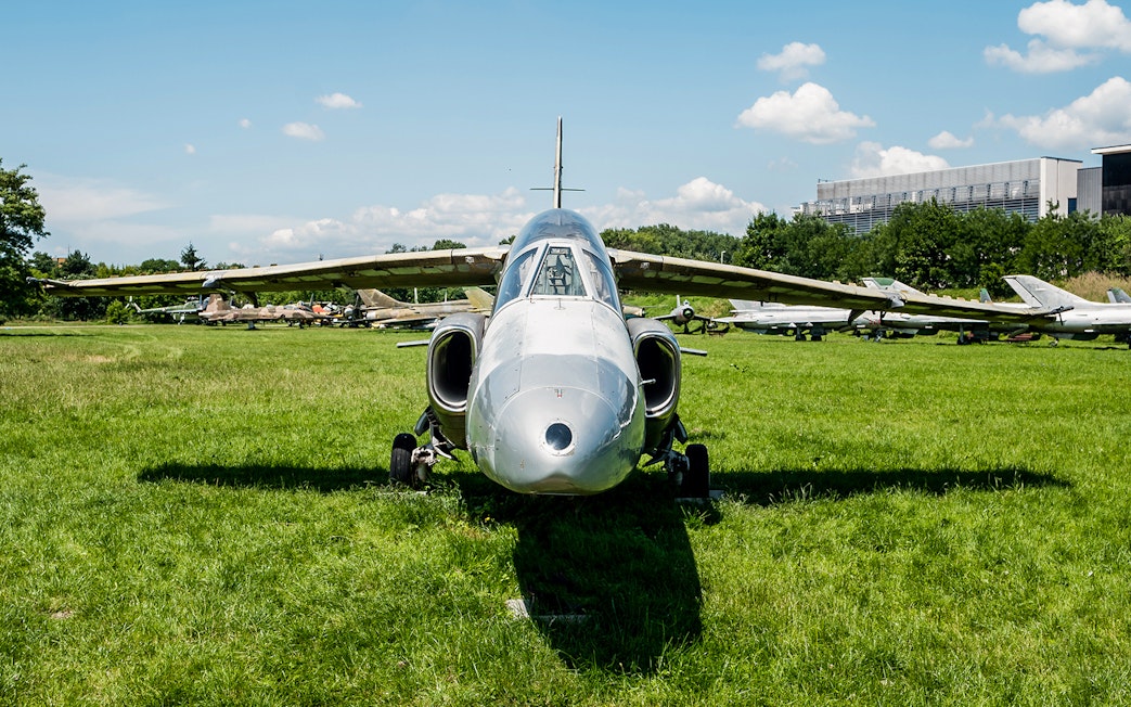 Jet aircraft displayed on grass at Polish Museum of Aviation.