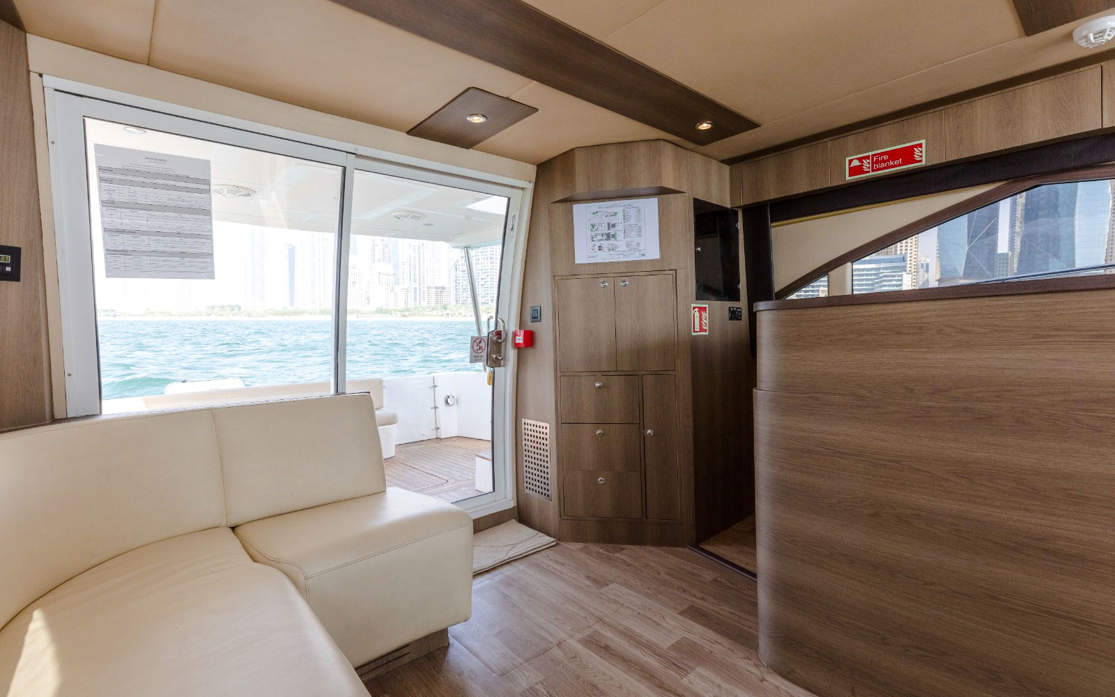 Interior view of Viktoriia Luxury Yacht with seating and ocean view through glass doors.