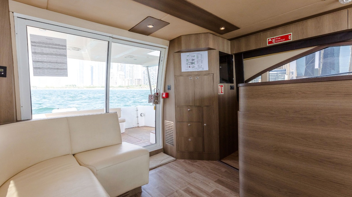 Interior view of Viktoriia Luxury Yacht with seating and ocean view through glass doors.