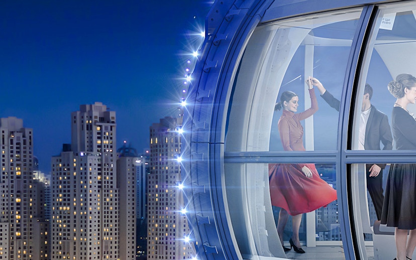 Visitors inside Ain Dubai wheel with city skyline in the background.