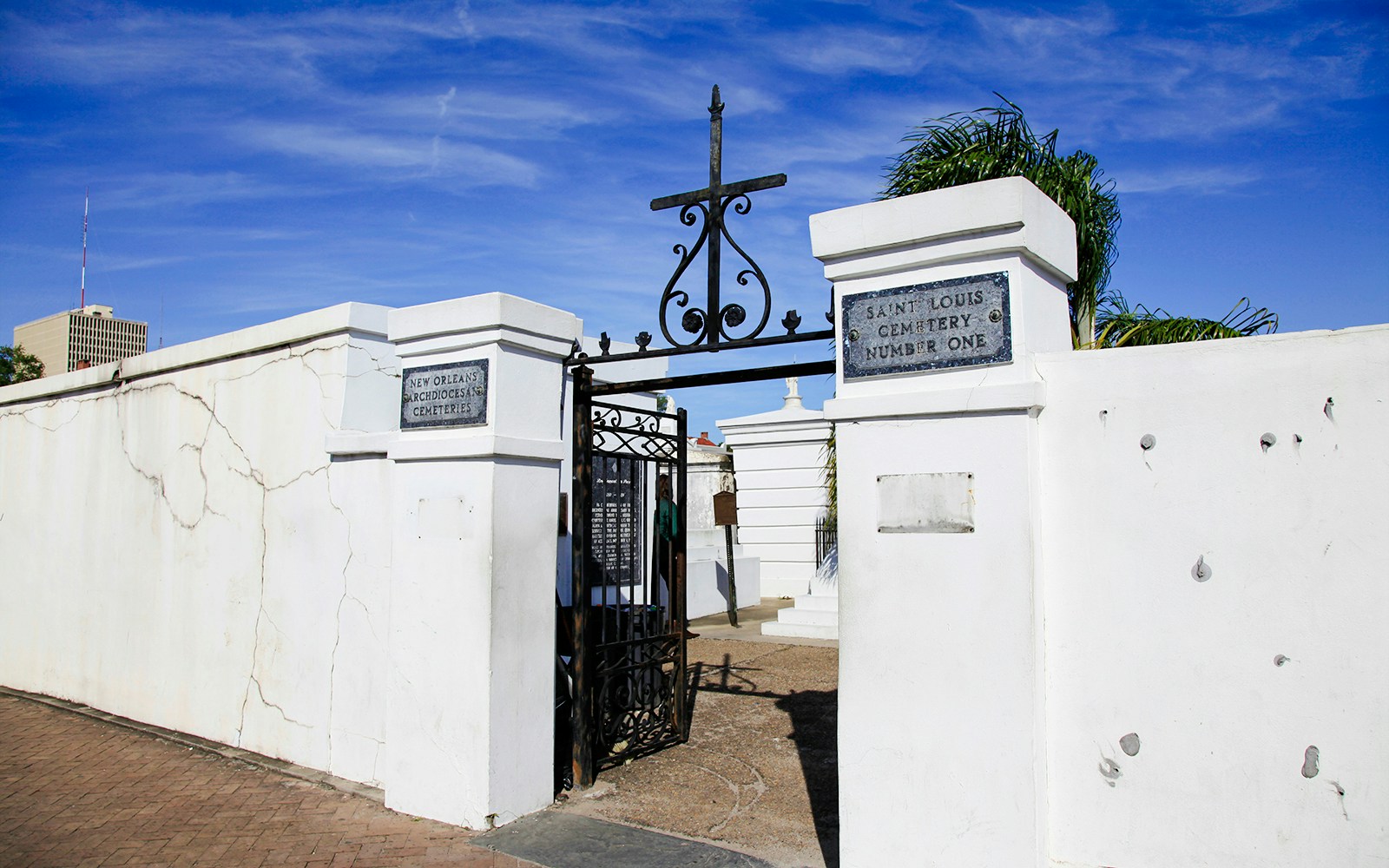 St. Louis Cemetery No. 1 entrance gate in New Orleans with historic tombs visible.