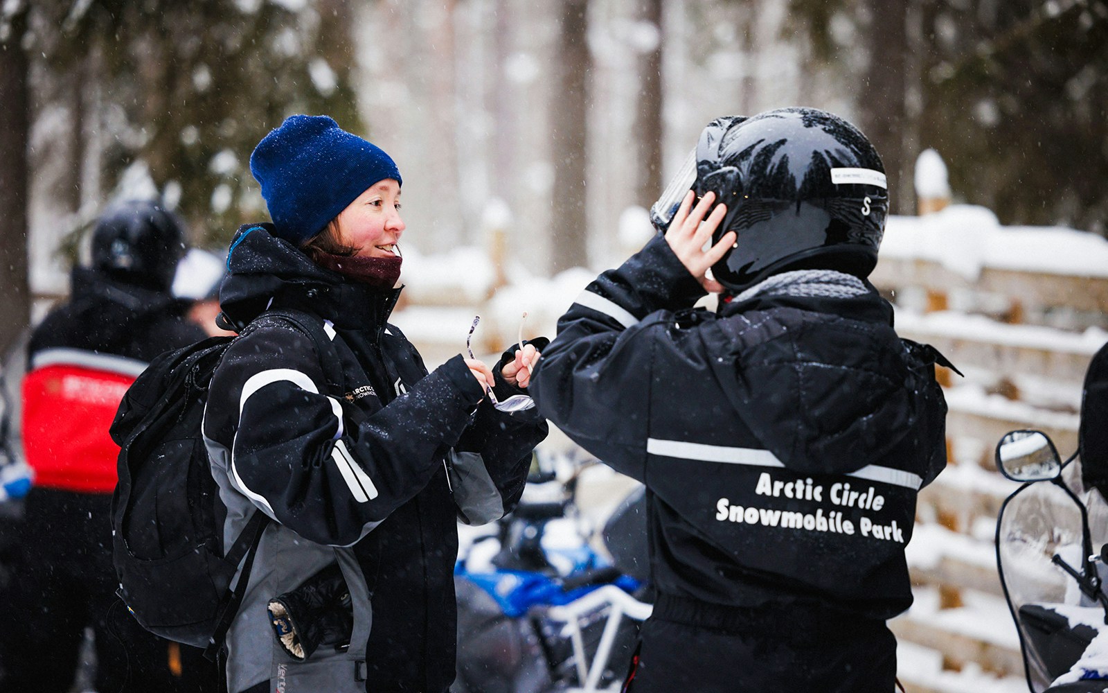 Snowmobile riders preparing gear at Arctic Circle Snowmobile Park, Lapland.