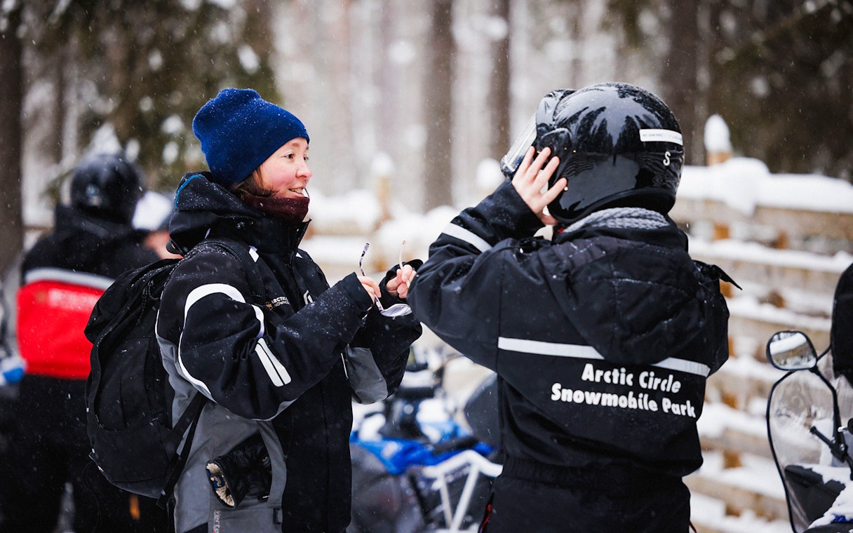 Snowmobile riders preparing gear at Arctic Circle Snowmobile Park, Lapland.