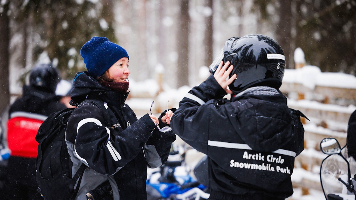 Snowmobile riders preparing gear at Arctic Circle Snowmobile Park, Lapland.