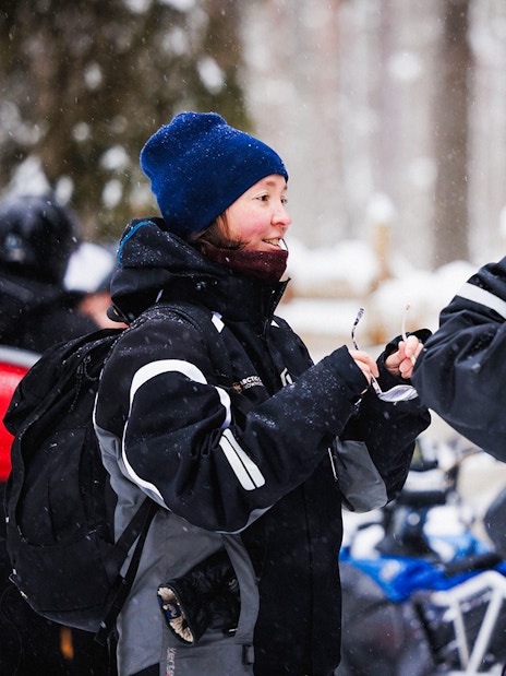 Snowmobile riders preparing gear at Arctic Circle Snowmobile Park, Lapland.