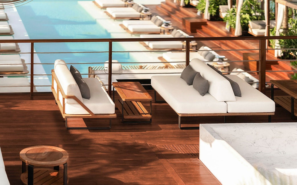 Sitting area with white sofas overlooking pool at Yona Beach Club, Phuket.