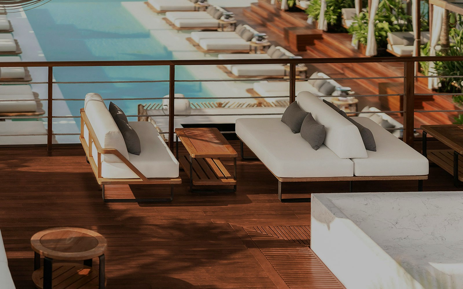 Sitting area with white sofas overlooking pool at Yona Beach Club, Phuket.