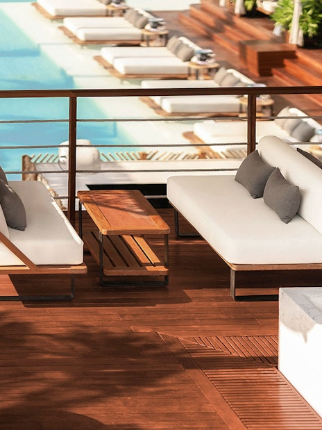 Sitting area with white sofas overlooking pool at Yona Beach Club, Phuket.