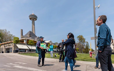 Guide welcoming tourists in front of Skylon Tower, Niagara Falls.