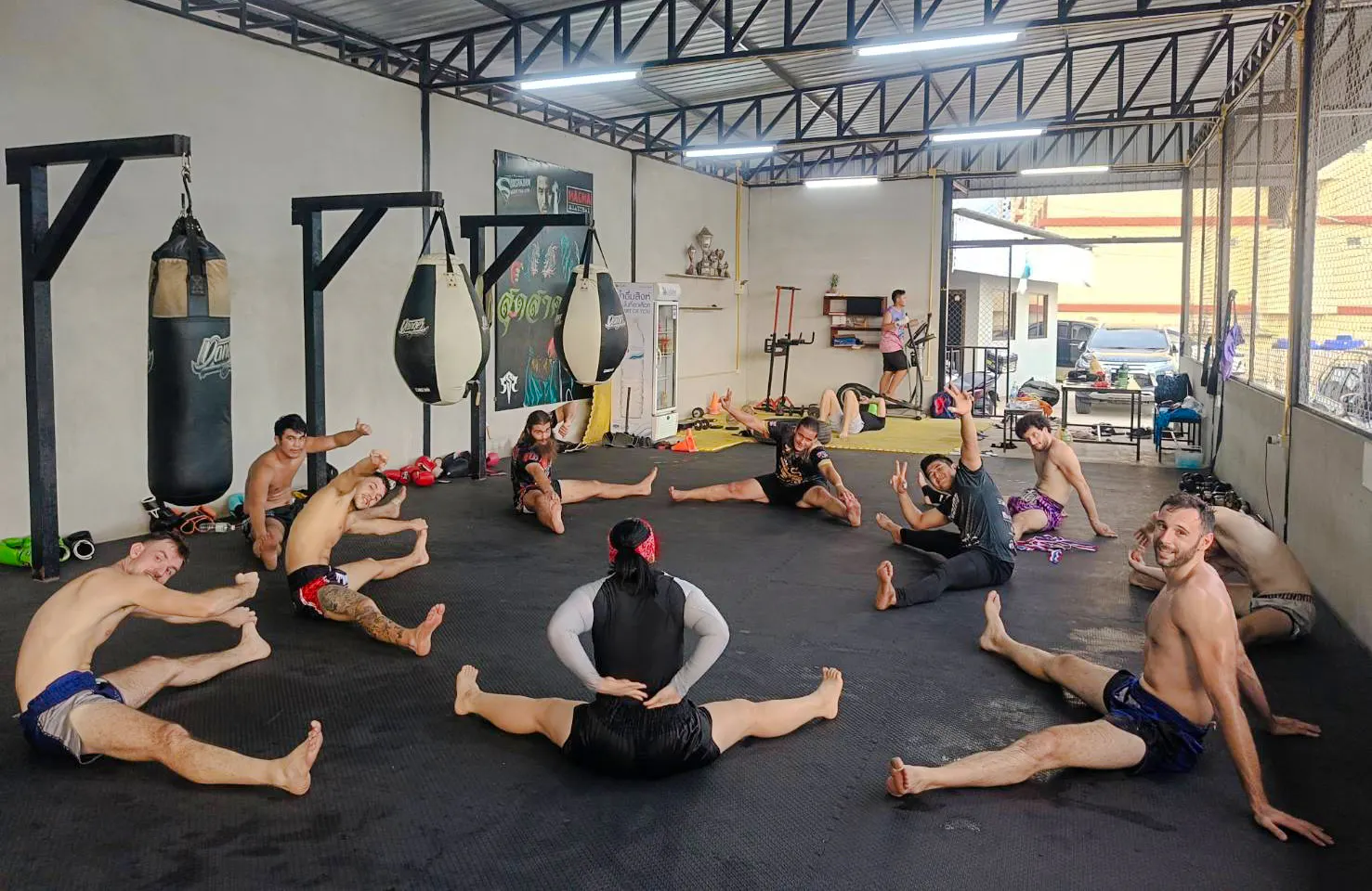 Beginners practicing stretches in a Muay Thai boxing class in Pattaya gym.