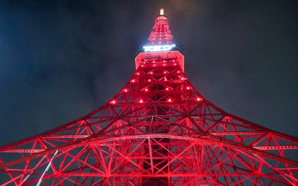 RED° TOKYO TOWER illuminated at night with red lights.