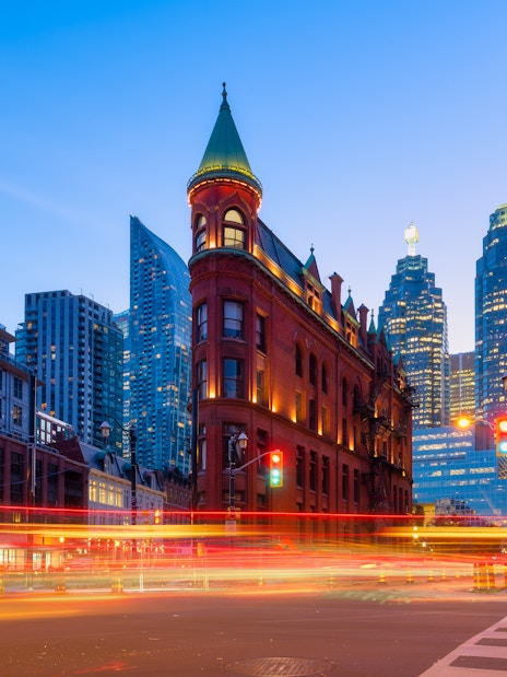 Gooderham Building with Toronto skyscrapers in the background at dusk.