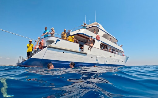People snorkeling near a boat during a bay cruise from Larnaca.