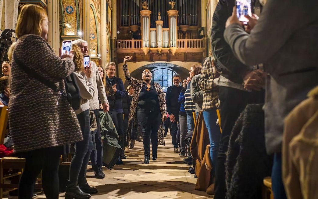 Orchestra performance in St Sulpice Church with audience capturing the moment.