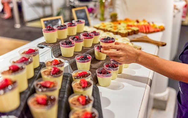 Hand selecting dessert from buffet on Spirit of Cairns dinner cruise, Australia.