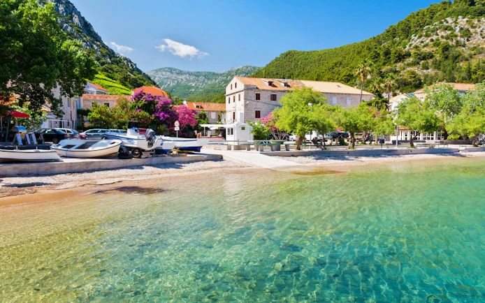 Stunning beach with clear water and boats on Peljesac peninsula, Dalmatia, Croatia.