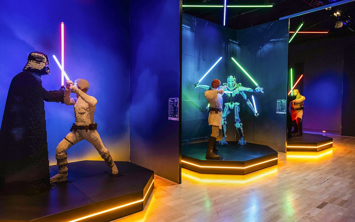 Lego sculptures of Darth Vader and Luke Skywalker in a lightsaber duel exhibit.