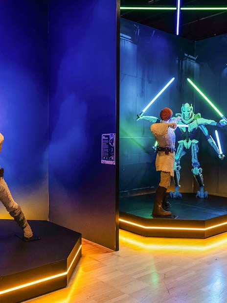 Lego sculptures of Darth Vader and Luke Skywalker in a lightsaber duel exhibit.