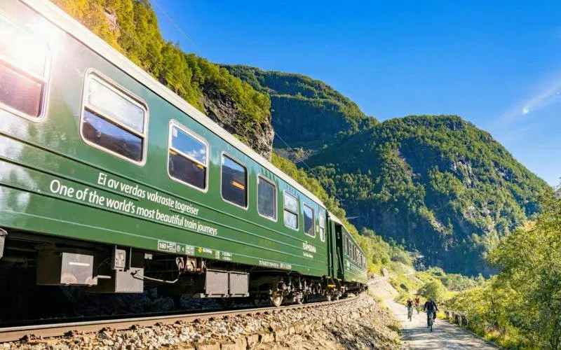 Train on Bergen to Flåm Railway with scenic mountain views, Norway.