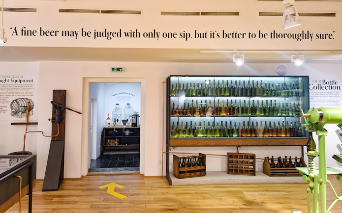 Prague Beer Museum interior with vintage bottle display and brewing equipment.