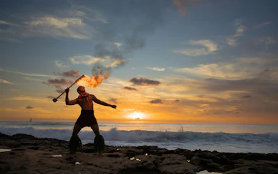 Fire dancer performing at sunset during Kaula-Luau in Hawaii.