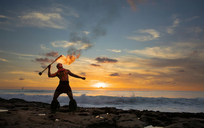 Fire dancer performing at sunset during Kaula-Luau in Hawaii.