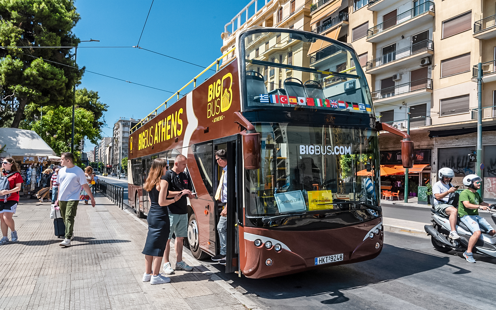 Passengers boarding Big Bus hop-on hop-off tour in Athens, Greece near Acropolis.