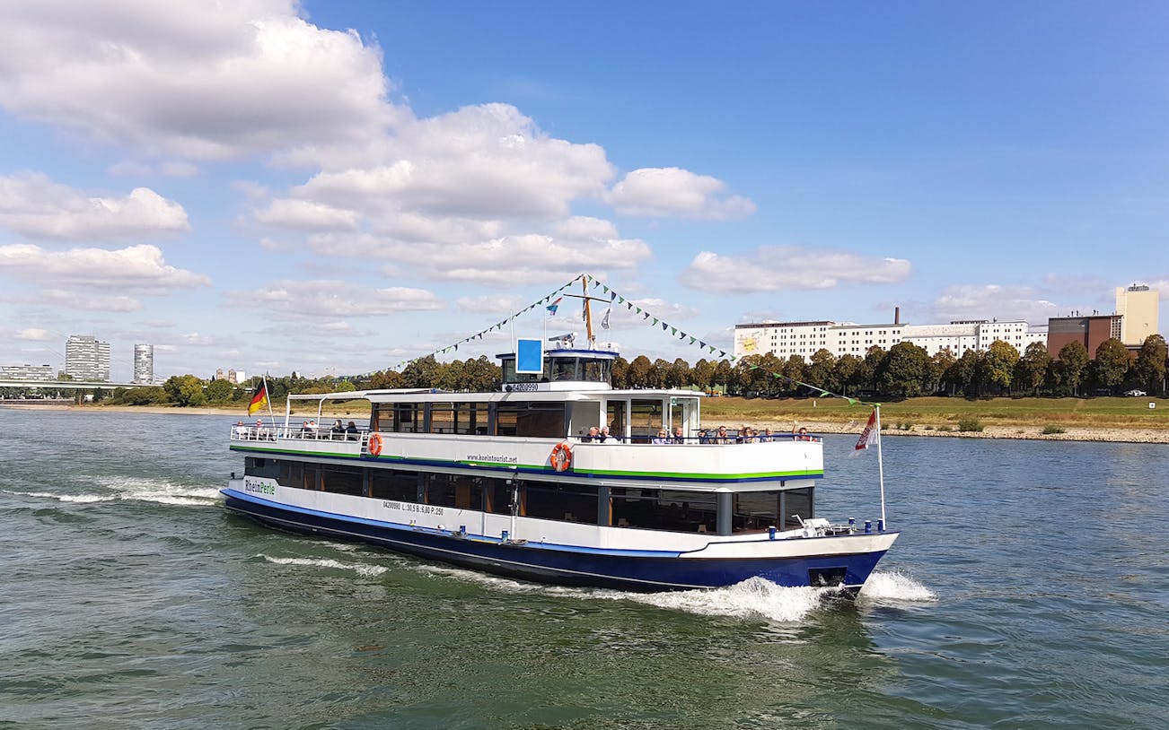 River cruise boat on the Rhine with Cologne skyline in the background.