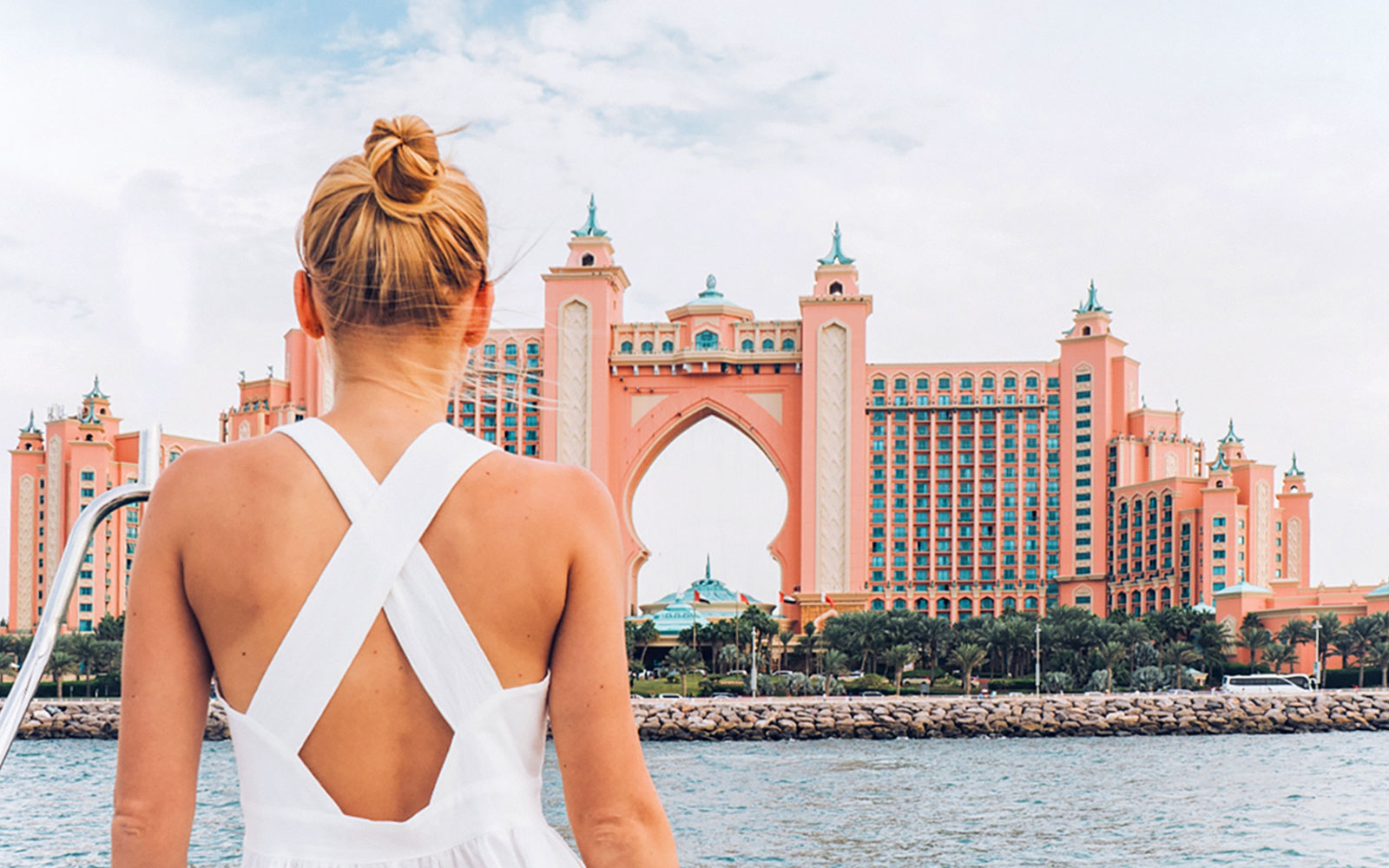 Person on yacht viewing Atlantis, The Palm in Dubai during luxury cruise.