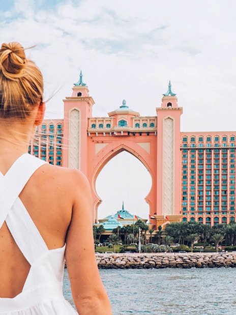 Person on yacht viewing Atlantis, The Palm in Dubai during luxury cruise.