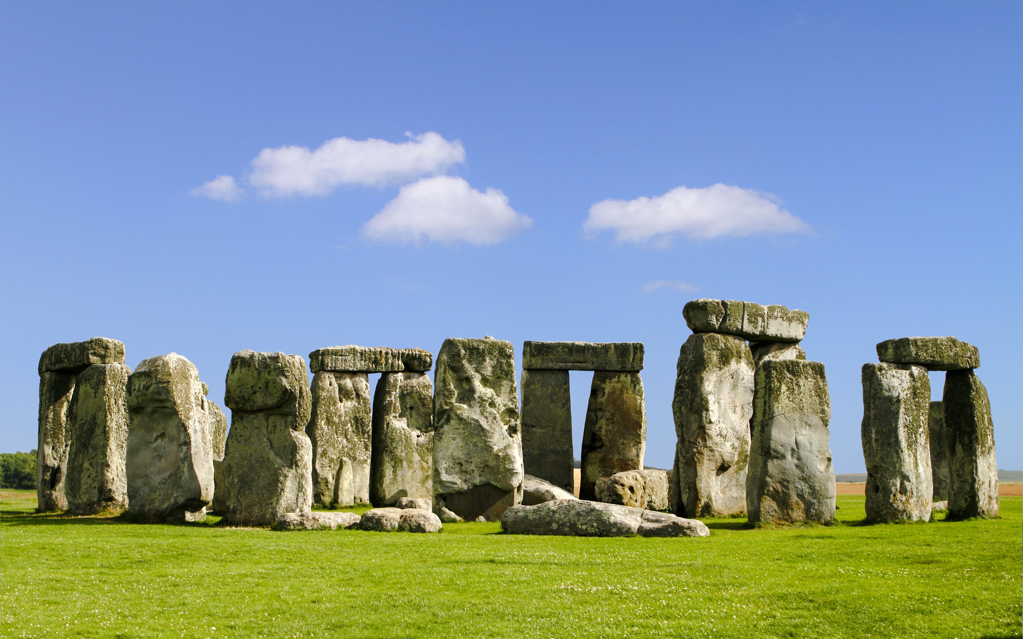 Stonehenge stone circle under blue sky during daytime in Wiltshire, England.