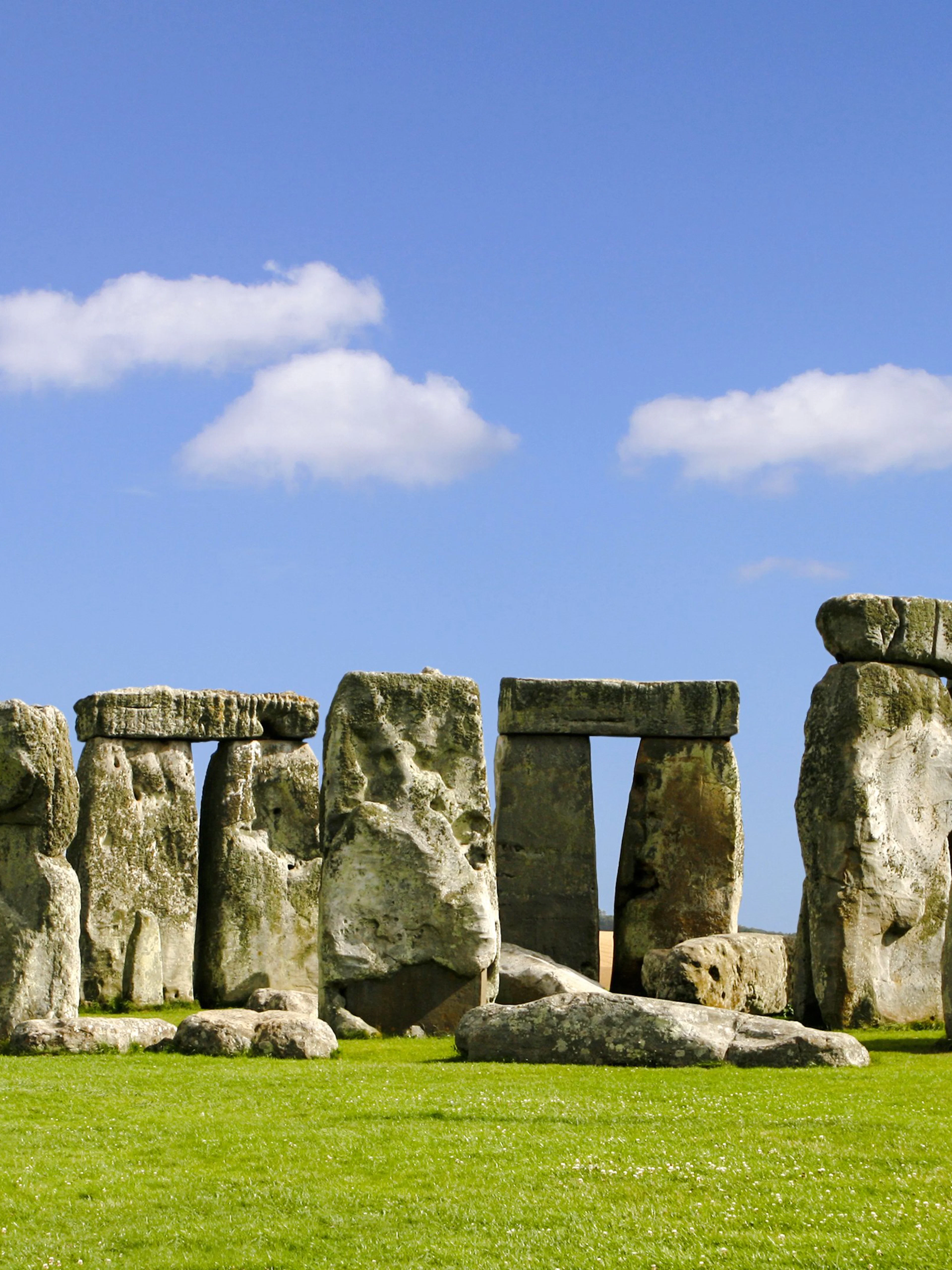 Stonehenge stone circle under blue sky during daytime in Wiltshire, England.