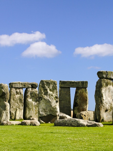 Stonehenge stone circle under blue sky during daytime in Wiltshire, England.