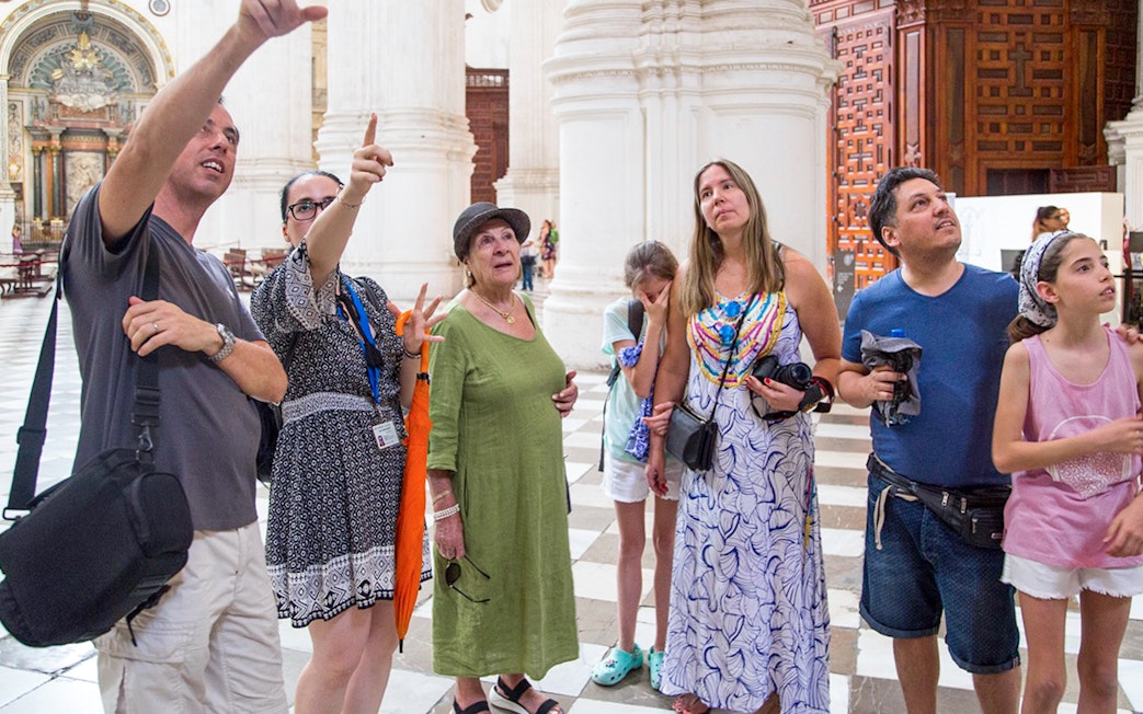 Group of tourists inside Granada Cathedral during guided tour.