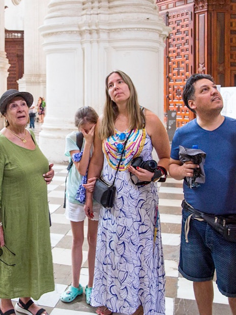 Group of tourists inside Granada Cathedral during guided tour.