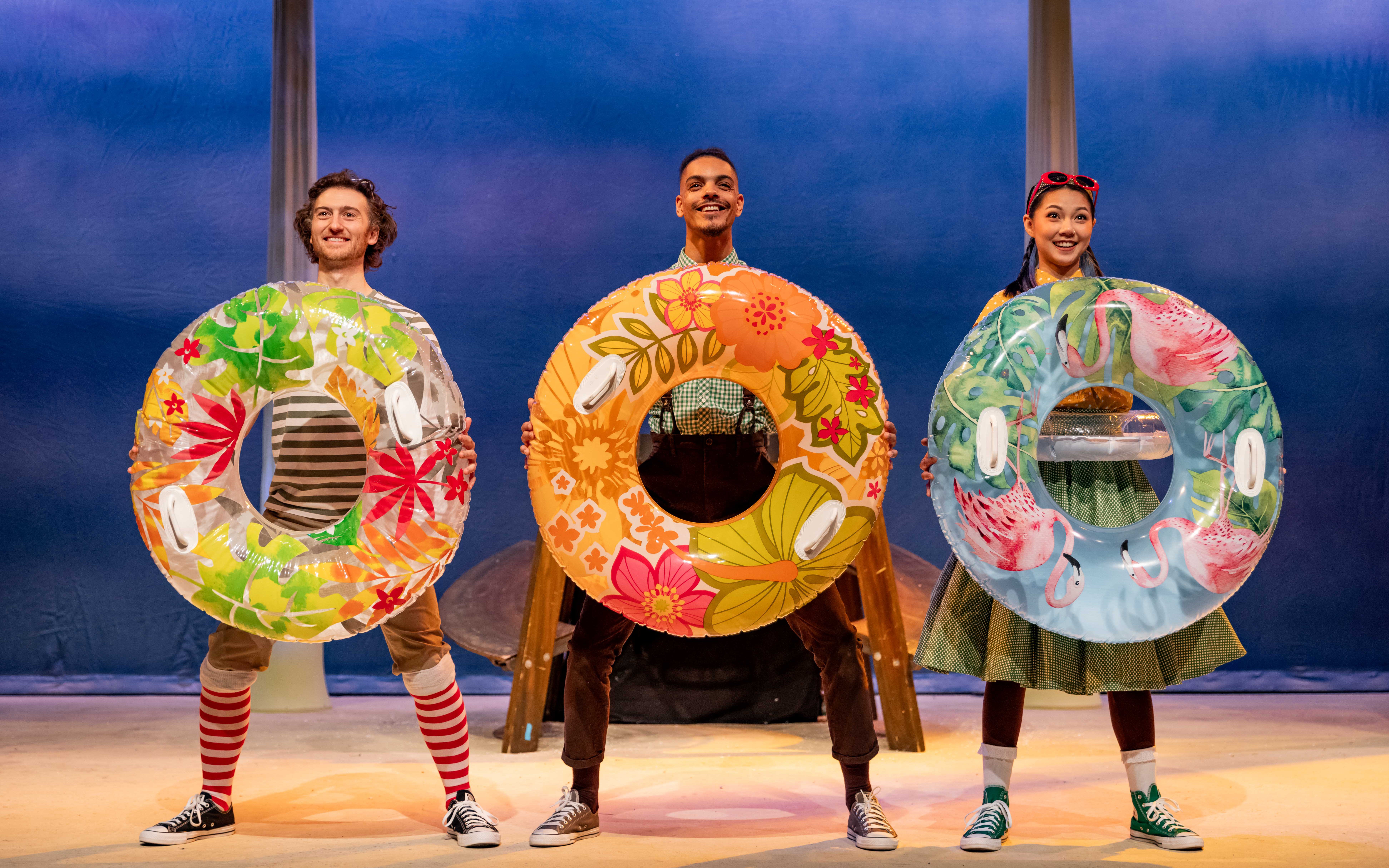 Performers with colorful float rings in Stick Man stage show, West End.