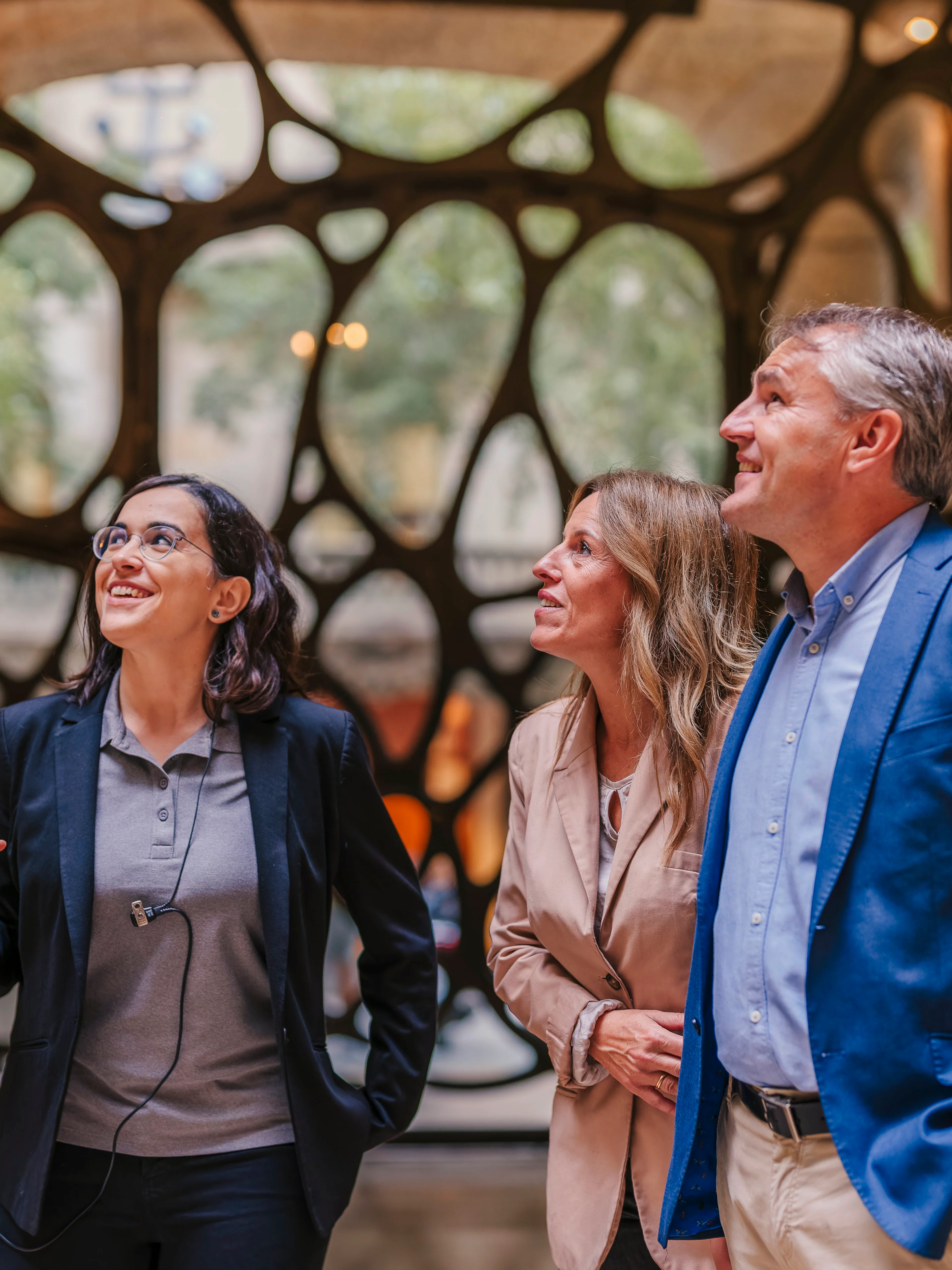 Tourist group with guide inside Casa Mila, Barcelona, admiring architecture.