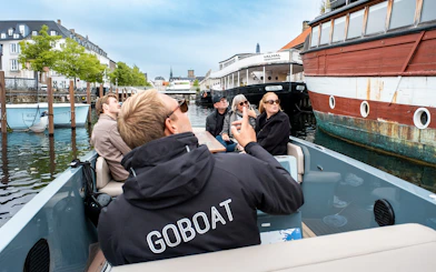 Guests on an electric boat tour in Copenhagen, viewing the city while the captain pedals.