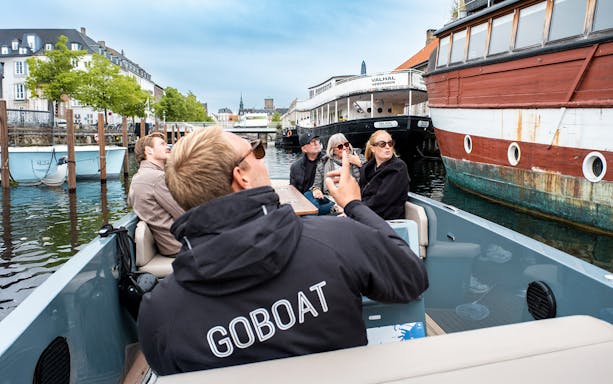 Guests on an electric boat tour in Copenhagen, viewing the city while the captain pedals.