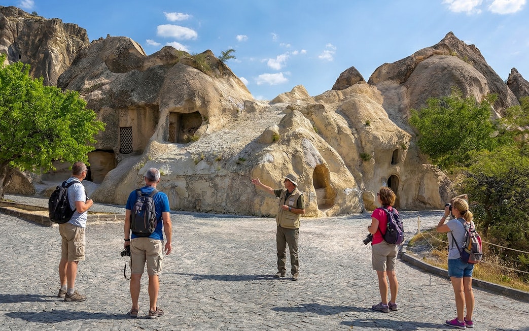 Tour guide explaining rock formations at Goreme Open-Air Museum, Cappadocia.