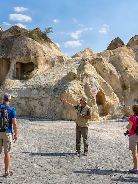 Tour guide explaining rock formations at Goreme Open-Air Museum, Cappadocia.
